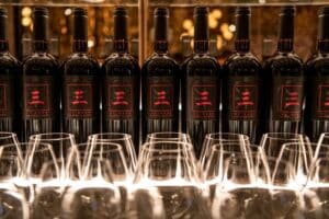 Several bottles of Wade Cellars' new Three by Wade 2020 California Cabernet Sauvignon lined up with glassware